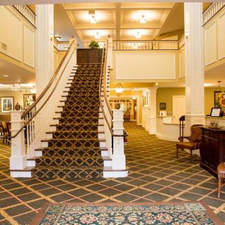 Elegant hotel lobby with a grand staircase and warm lighting.