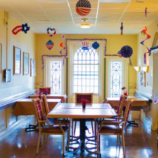 A vibrant dining area adorned with colorful decorations, featuring tables and chairs set up for gatherings.