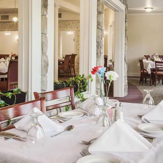 An elegantly set dining area in a restaurant with neatly arranged tables and chairs.