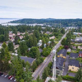 Aerial view of a small town surrounded by lush greenery and roads.