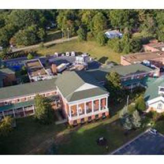 Aerial view of a campus building surrounded by trees.