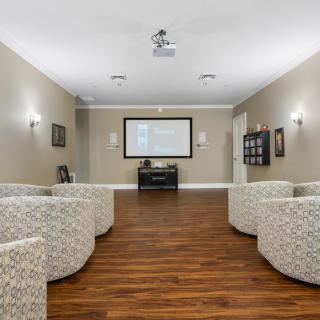 A modern living room with comfortable seating and a projector screen.