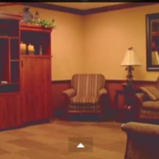 A cozy living room with a sofa, armchair, and wooden furniture.