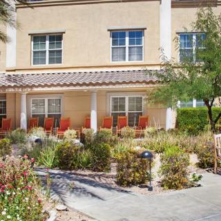 A residential building with a landscaped garden and outdoor seating area.
