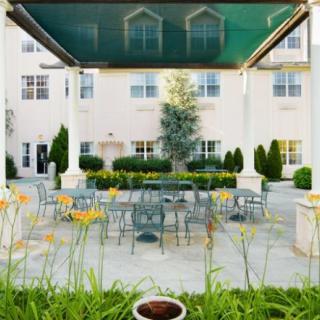 A charming outdoor patio area with tables, chairs, and lush greenery.
