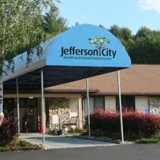 Entrance of Jefferson City facility featuring a blue awning and landscaped surroundings.