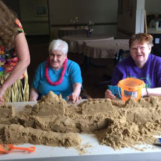 Elderly residents enjoying a fun indoor sand crafting session.