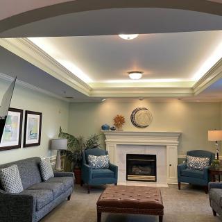 A well-decorated living room featuring a comfortable seating arrangement, a central fireplace, and ambient lighting.