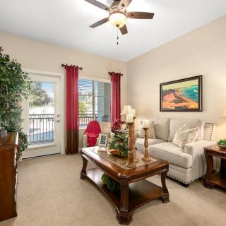 A cozy living room with a beige sofa, wooden coffee table, and decorative plants.