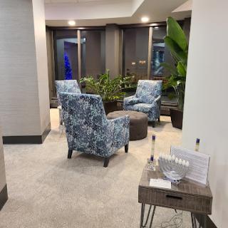 A cozy lobby seating area featuring stylish chairs and greenery.