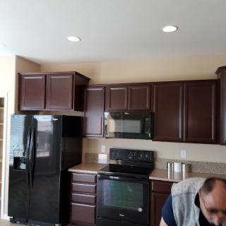 A modern kitchen featuring dark wood cabinetry and sleek appliances.