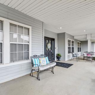 A welcoming porch with seating and decorative elements in front of a house.