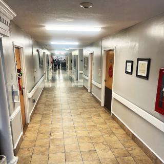 A well-lit and spacious hallway with tiled flooring and multiple doors.