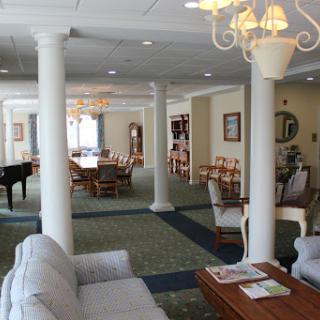 A spacious and inviting lounge area featuring a mix of comfortable seating, dining tables, and elegant lighting.