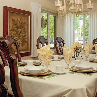 A well-decorated dining room with an elegant table setting and chandelier.