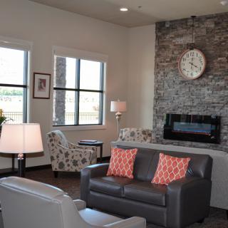 A modern living room featuring a stone fireplace, comfortable seating, and stylish decor.