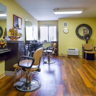 A well-organized hair salon with wooden flooring and mirrored walls.