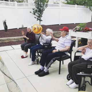A group of elderly people sitting outdoors, enjoying a peaceful moment together.