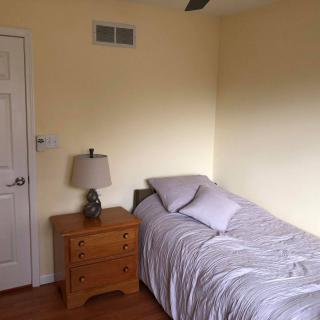 A minimalist bedroom with a single bed and nightstand.