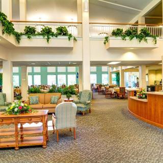 A spacious and bright lobby area with comfortable seating and indoor plants.