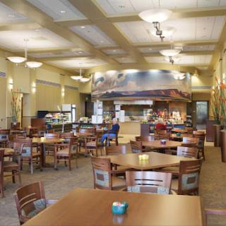 A spacious cafeteria with neatly arranged tables and chairs.