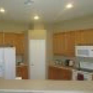 A kitchen with wooden cabinets, white appliances, and a central countertop.