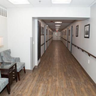 A view of a long, well-lit hallway with seating arrangements and decorative elements along the walls.