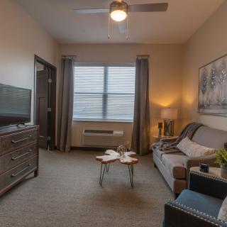 A cozy living room with a modern aesthetic, featuring a sofa, television, and coffee table.