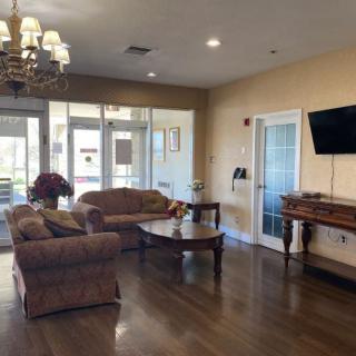 A cozy living room with sofas, a chandelier, and a television.