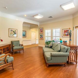 A cozy living room with couches, chairs, and artwork on the walls.