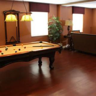 A cozy game room with a pool table and elegant lighting.