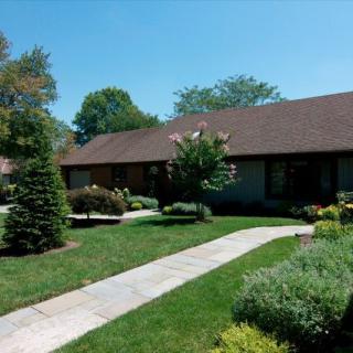 A house with a well-maintained garden and sidewalk on a sunny day.