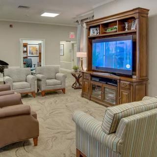 A cozy living room with comfortable seating and a large television entertainment center.