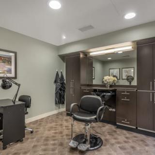 A modern barbershop interior with a salon chair and workstation.