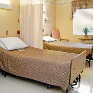 A shared hospital room with two beds and a curtain divider.