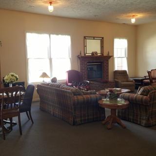A cozy living room featuring sofas, a fireplace, and ample natural light.