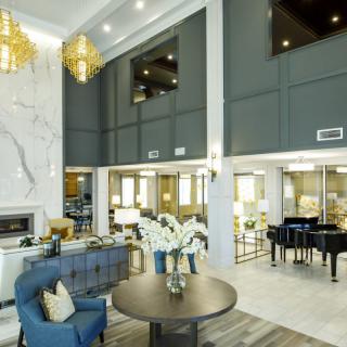 A luxurious and modern lobby interior featuring elegant chandeliers and a grand piano.