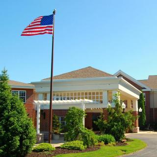 A building with an American flag flying outdoors under a clear blue sky.