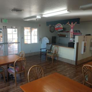 An interior view of a small restaurant dining area with tables and chairs.