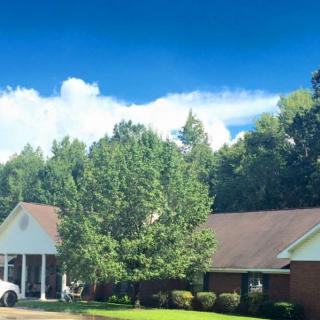 A suburban house with a neatly maintained front yard and a clear blue sky.