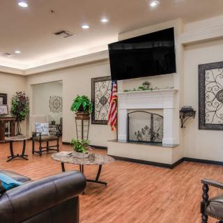 A modern living room featuring comfortable furniture, a large television above the fireplace, and tasteful decor.