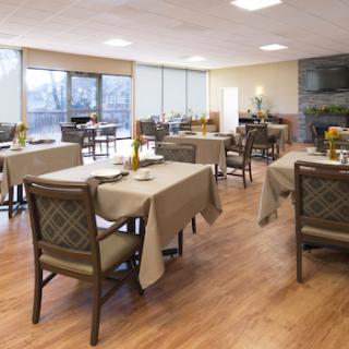 A spacious and well-lit dining area with neatly arranged tables and chairs.