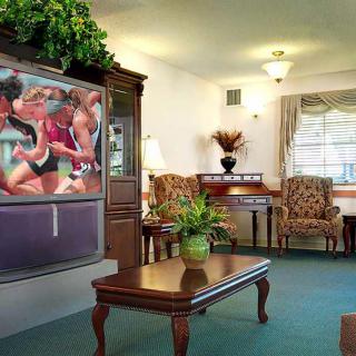 A cozy living room with classic furniture and a large TV.