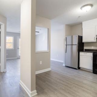 A modern and freshly renovated kitchen area with open layout and stainless steel appliances.