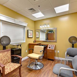 A cozy hair salon interior with styling chairs, a mirror, and hair dryers.