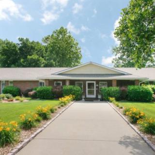 A suburban house with a neatly landscaped front yard and driveway.
