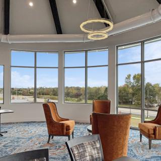 A modern seating area with large windows providing natural light and an outdoor view.
