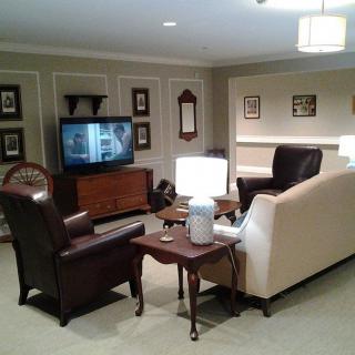 A cozy living room with a television, sofa, armchairs, and a coffee table.