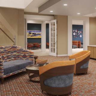 A cozy living room with modern furniture and a carpeted floor.