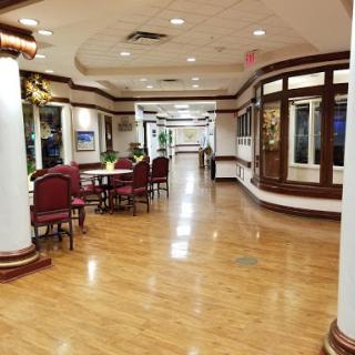 A spacious and well-lit interior hallway featuring dining areas and elegant decor.